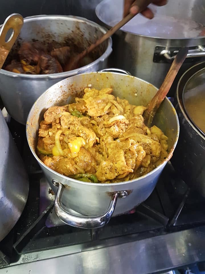 Curry goat and chicken cooking in large pots at Bready's Delights